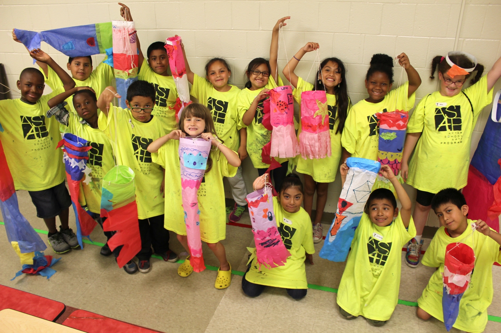 A group of kids in ASAP t-shirts with handmade kites