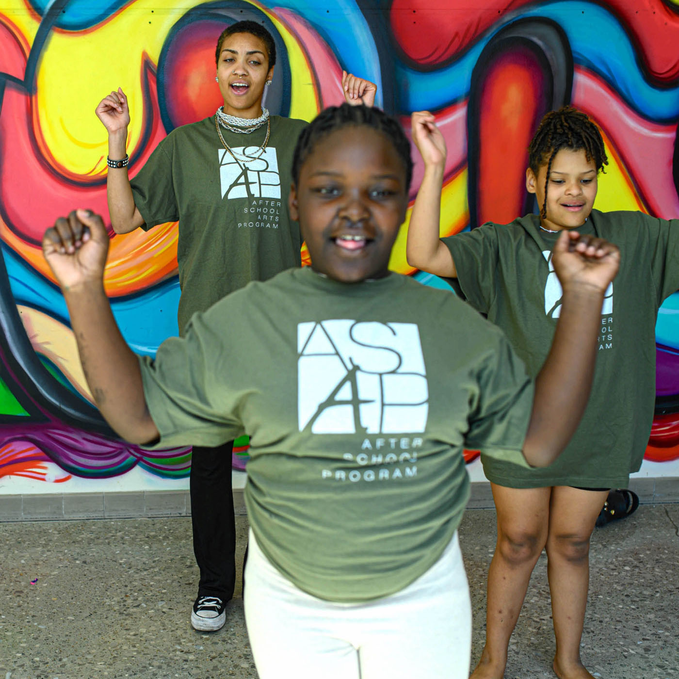 Three girls in ASAP green shirts performing