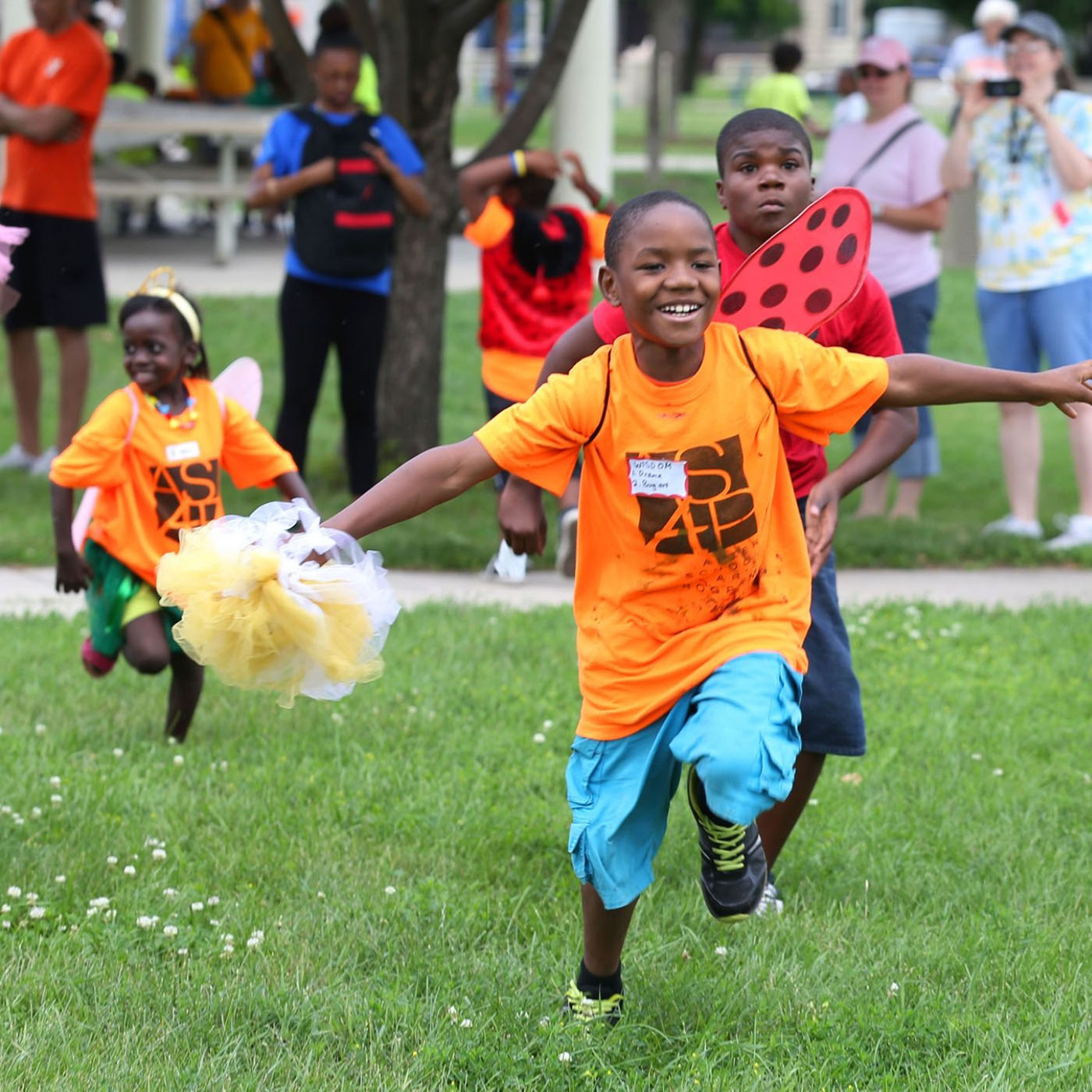 Three kids in shirts and costumes running